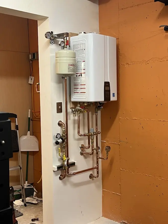 Plumbing technician inspecting water heater connections in South Bend